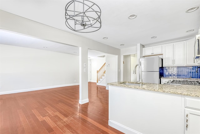 kitchen featuring decorative light fixtures, white cabinetry, tasteful backsplash, sink, and stainless steel fridge