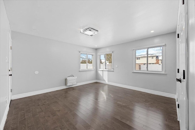 unfurnished room with dark hardwood / wood-style flooring