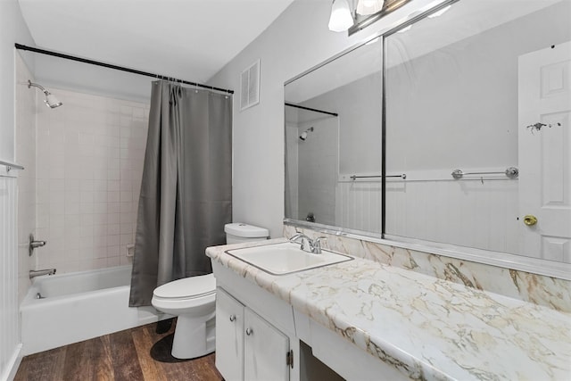 full bathroom featuring wood-type flooring, shower / bath combo, vanity, and toilet