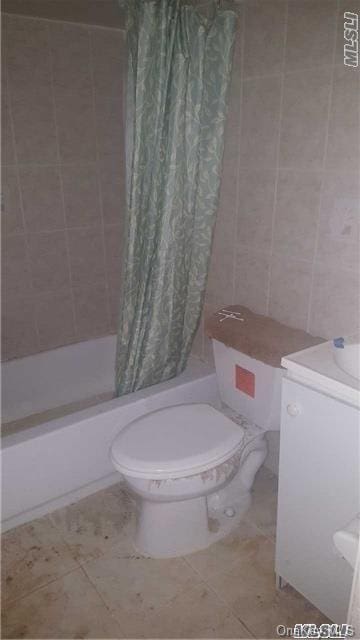 bathroom with tile patterned floors, toilet, and shower / tub combo