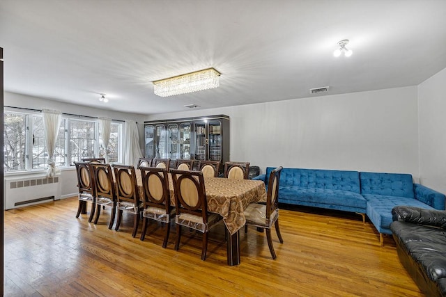 dining space with radiator and light hardwood / wood-style floors