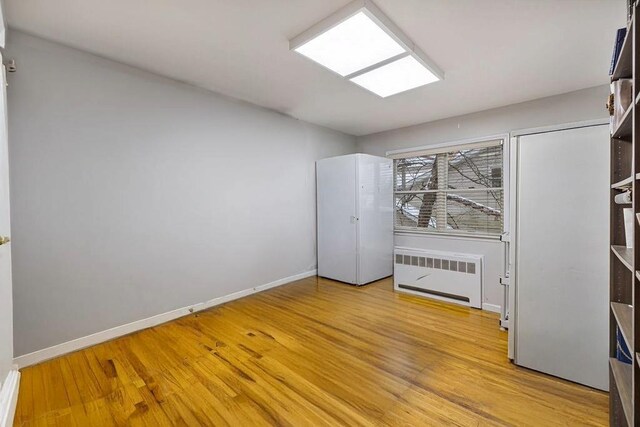 spare room with radiator and light hardwood / wood-style flooring