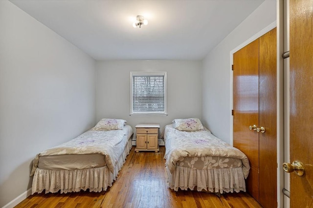 bedroom with hardwood / wood-style flooring and baseboard heating