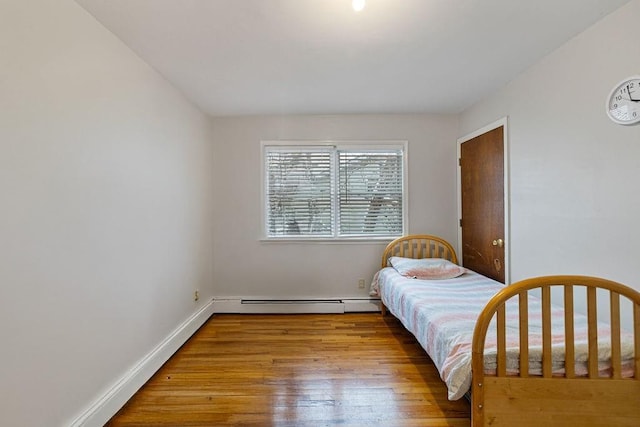 bedroom featuring a baseboard radiator and light hardwood / wood-style flooring