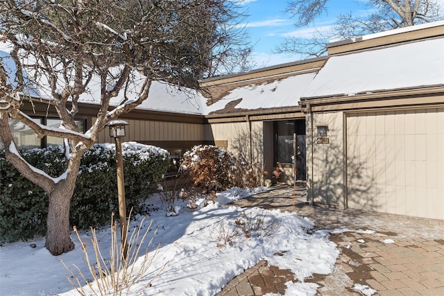 snow covered property featuring a garage