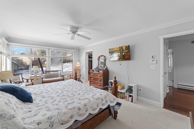 bedroom featuring a walk in closet, carpet, ceiling fan, baseboard heating, and crown molding