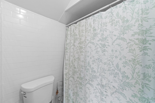 bathroom featuring a shower with curtain and toilet