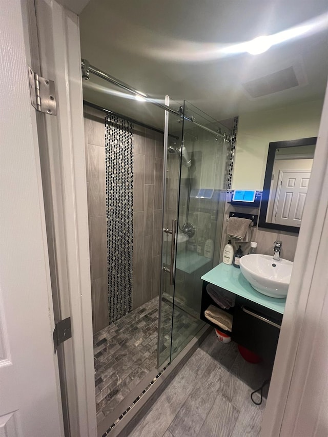 bathroom with vanity and a shower with door