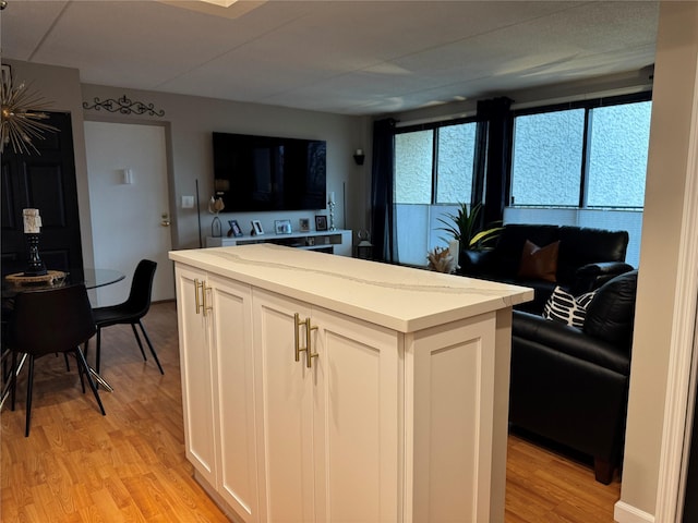 kitchen featuring a kitchen island, white cabinets, and light hardwood / wood-style floors