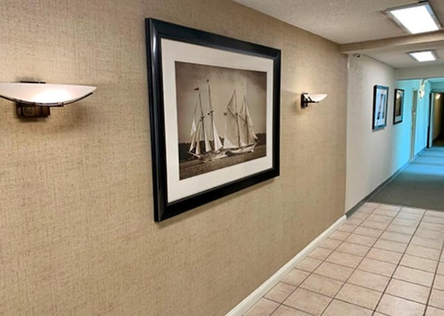 hallway with light tile patterned floors and a textured ceiling