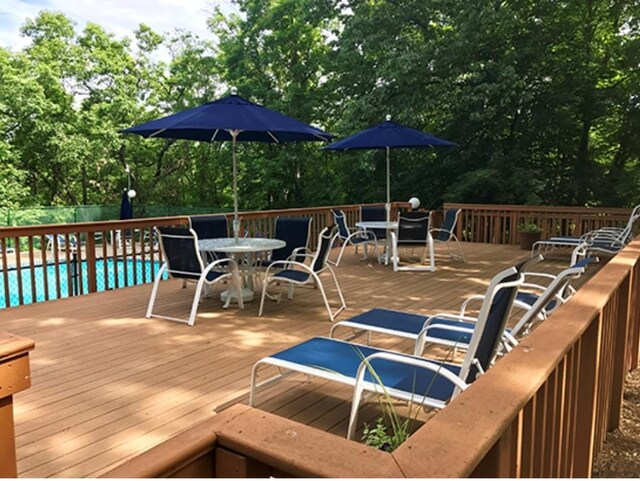 wooden deck featuring a fenced in pool