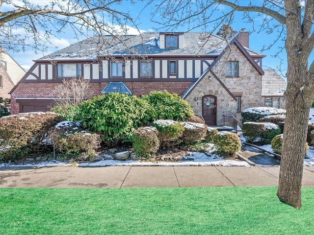 tudor-style house with a front lawn