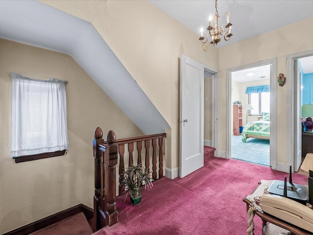 corridor with lofted ceiling, carpet flooring, and a notable chandelier