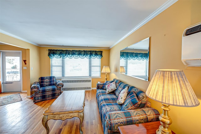 living room with hardwood / wood-style flooring, radiator, crown molding, and a healthy amount of sunlight