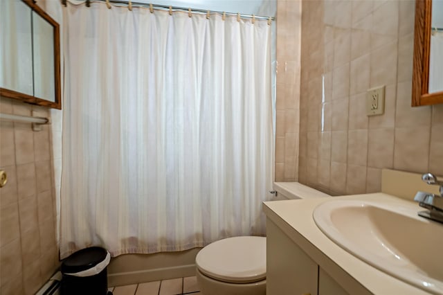 full bathroom featuring toilet, shower / bath combo with shower curtain, tile walls, tile patterned floors, and vanity