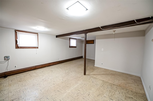 basement featuring a healthy amount of sunlight and light parquet flooring