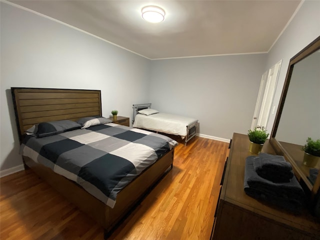 bedroom featuring hardwood / wood-style flooring and ornamental molding