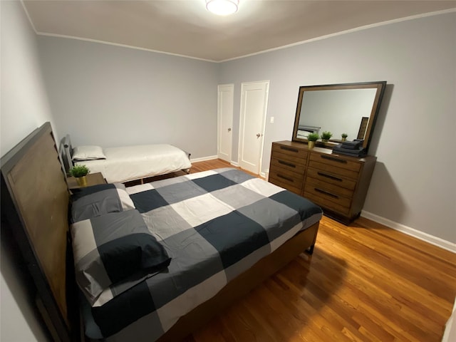 bedroom with crown molding and wood-type flooring