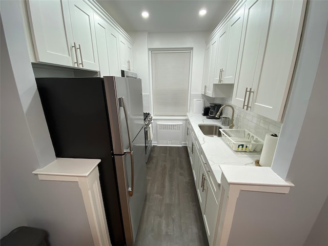 kitchen featuring sink, stainless steel refrigerator, dark hardwood / wood-style floors, light stone countertops, and white cabinets