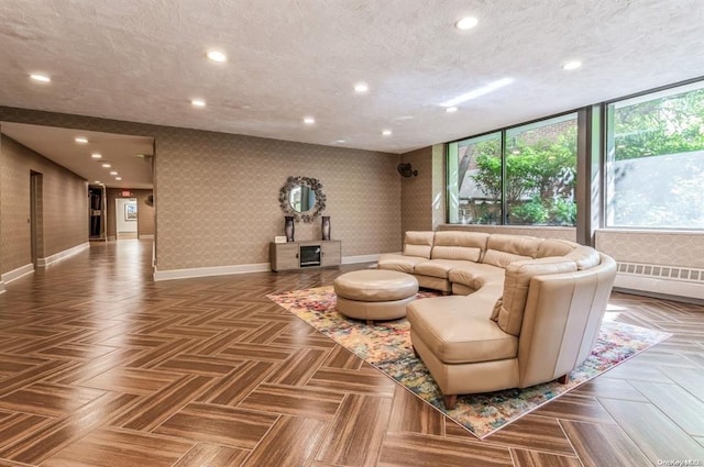 living room featuring a textured ceiling, a baseboard heating unit, and parquet floors