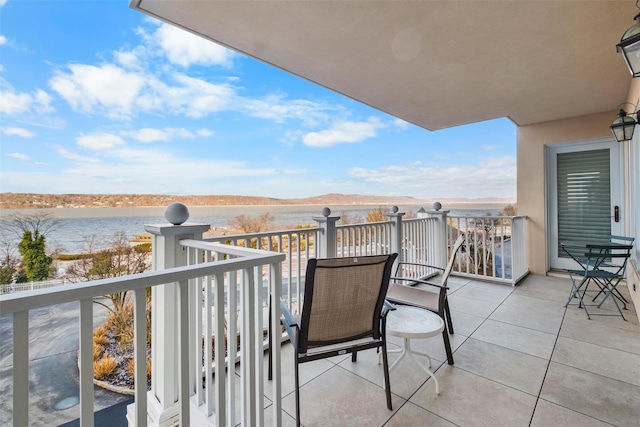 balcony featuring a water and mountain view