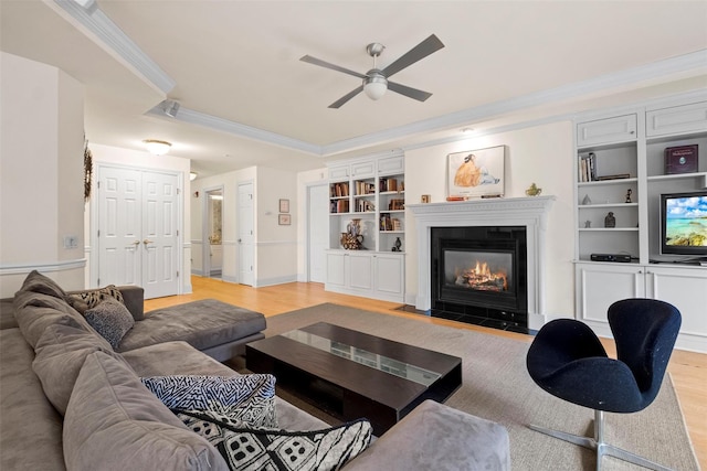 living room featuring ornamental molding, ceiling fan, built in features, and light wood-type flooring