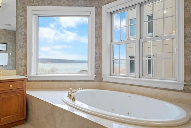 bathroom featuring vanity, tiled bath, and a water view