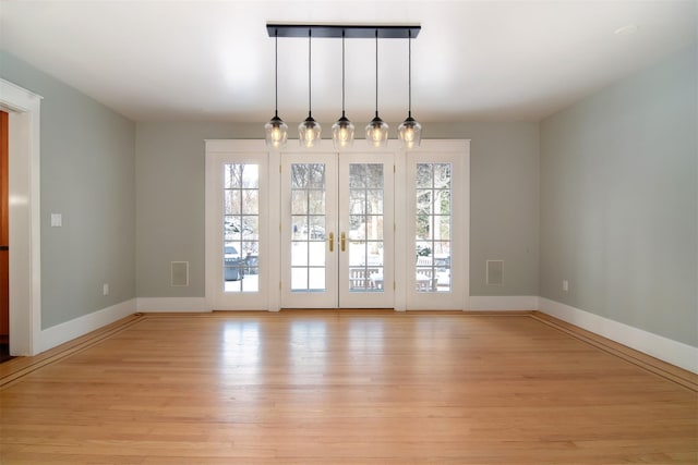 unfurnished dining area with french doors and light wood-type flooring