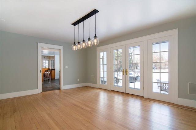 unfurnished room with french doors and light wood-type flooring