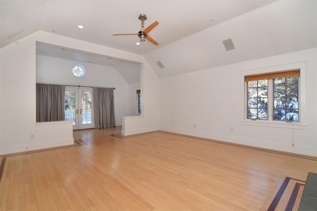 unfurnished living room featuring vaulted ceiling, ceiling fan, light hardwood / wood-style floors, and french doors