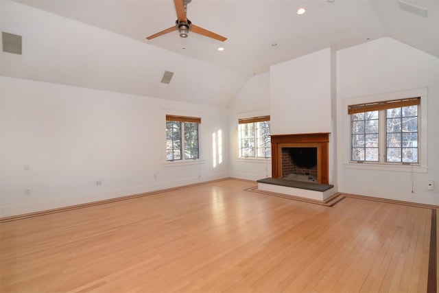 unfurnished living room with light hardwood / wood-style flooring, a healthy amount of sunlight, and vaulted ceiling