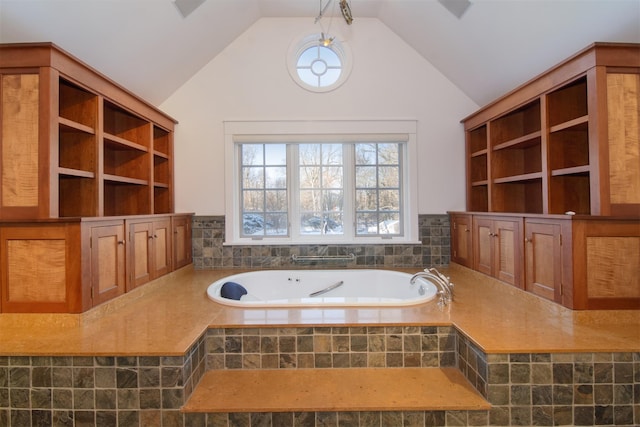 bathroom with tiled bath and vaulted ceiling