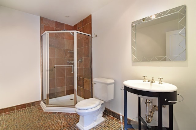 bathroom featuring toilet, sink, a shower with door, and tile patterned flooring