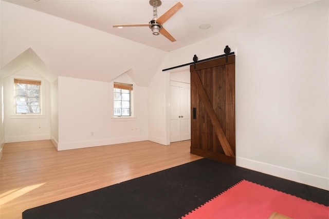 interior space with lofted ceiling, a barn door, and a healthy amount of sunlight