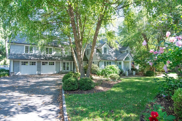 view of front of house with a garage and a front lawn