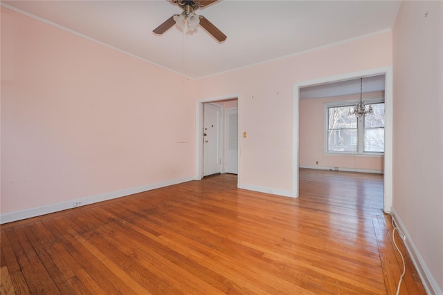 spare room featuring ceiling fan with notable chandelier, light hardwood / wood-style flooring, and crown molding