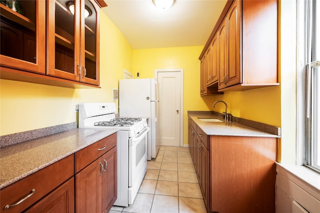 kitchen with light stone counters, sink, white appliances, and light tile patterned flooring