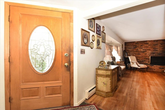 entrance foyer featuring a wealth of natural light, a baseboard heating unit, and wood-type flooring