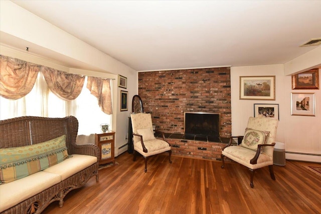 living area with a fireplace, a baseboard radiator, and dark wood-type flooring