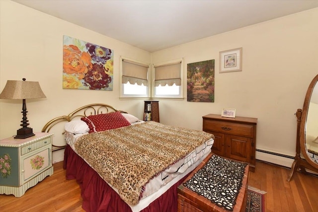 bedroom featuring baseboard heating and hardwood / wood-style floors