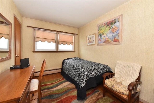 bedroom with hardwood / wood-style floors and baseboard heating