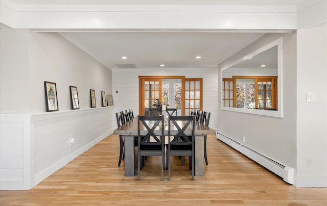 dining room featuring light hardwood / wood-style floors, french doors, a healthy amount of sunlight, and a baseboard radiator