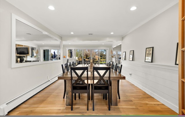 dining area featuring a baseboard radiator, crown molding, beamed ceiling, and light wood-type flooring