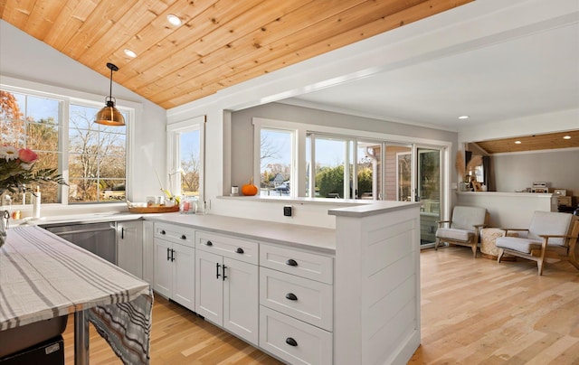 kitchen featuring white cabinets, lofted ceiling, wood ceiling, decorative light fixtures, and light wood-type flooring