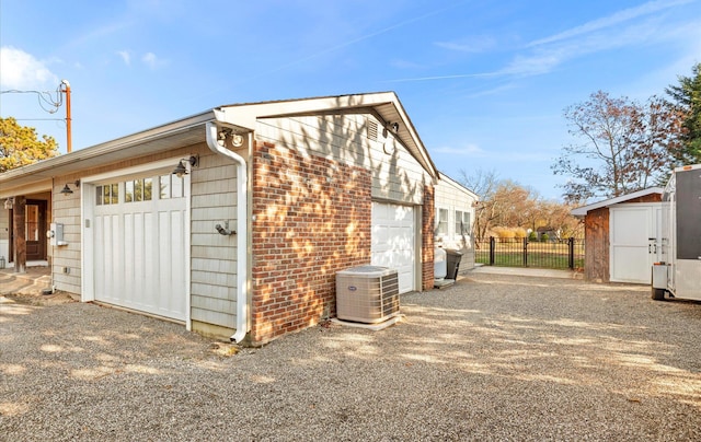 view of property exterior featuring a garage, cooling unit, and a storage unit