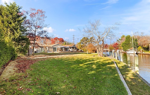 view of yard featuring a dock and a water view