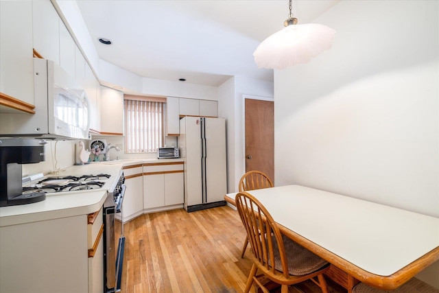 kitchen featuring white cabinetry, white appliances, light hardwood / wood-style flooring, and pendant lighting