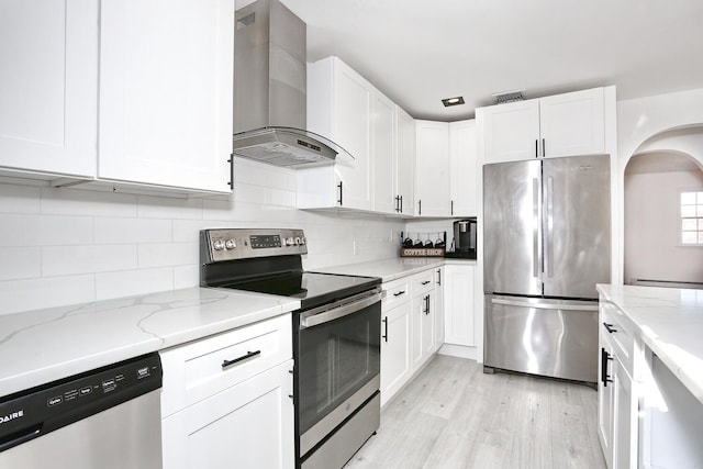 kitchen featuring extractor fan, stainless steel appliances, white cabinets, and light stone countertops