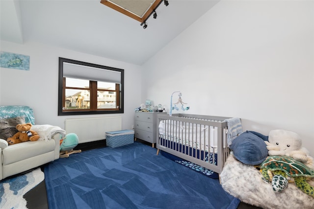 bedroom with radiator, vaulted ceiling, dark carpet, and a nursery area