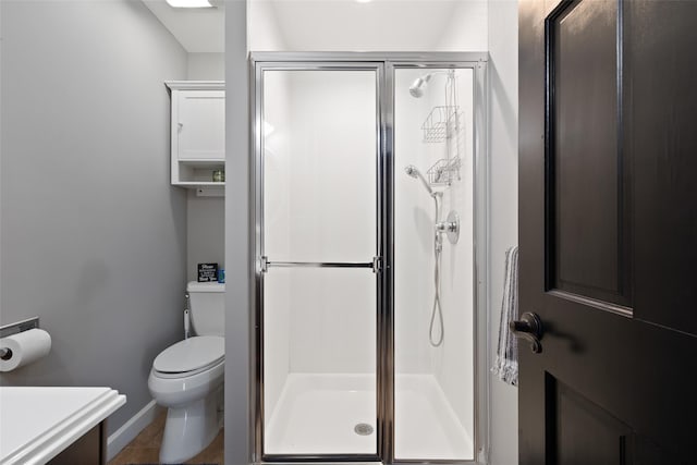 bathroom featuring a shower with shower door, tile patterned floors, toilet, and vanity